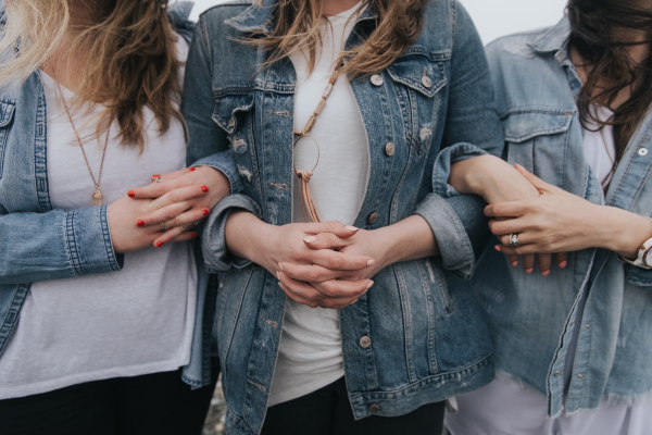 Women in denim with arms linked